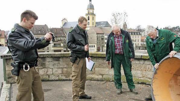 Während Timo Hofmann und Thomas Schneider von der PI Kitzingen den Schaden dokumentieren, blicken die Stadtgärtner Edi Ritz und Johannes Lindner verdrossen auf den beschädigten Pflanzkübel.