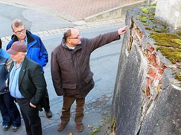 Bitte nicht berühren! Ein leichter Druck mit dem Zeigefinger reichte aus, damit Werner Platsch ein Stück aus der maroden Stützmauer in Autenhausen brechen konnte. Foto: Berthold Köhler