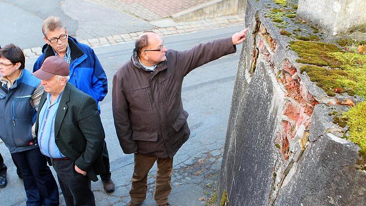 Bitte nicht berühren! Ein leichter Druck mit dem Zeigefinger reichte aus, damit Werner Platsch ein Stück aus der maroden Stützmauer in Autenhausen brechen konnte. Foto: Berthold Köhler