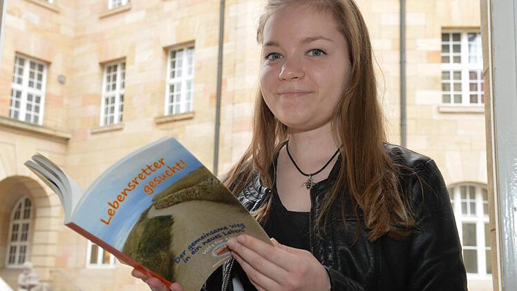 Anja Roith blättert in dem Buch, das der nach ihr benannte Verein "Hilfe für Anja" zum 15-jährigen Bestehen herausbrachte. Foto: Ronald Rinklef