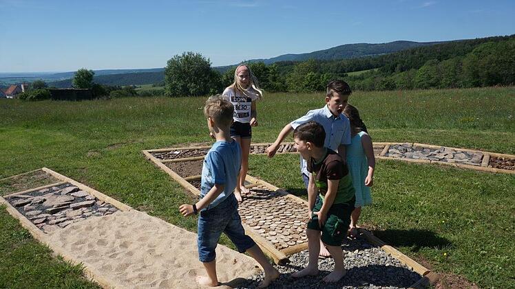Die Kinder freuen sich über den Barfußpfad. Am meisten schmerzen die  kleine Zapfen und die spitzigen Steine. Foto: Marion Eckert
