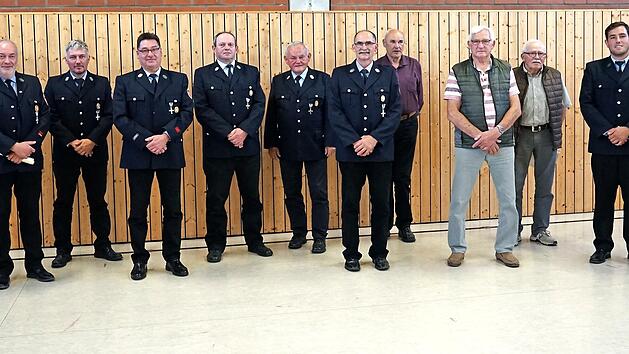 Kommandant Andreas Seidenthal (links) gratuliert den langj&auml;hrigen Mitgliedern zu ihrer Ehrung.