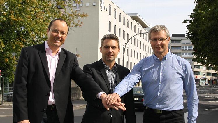 Auf die neuen Büros im Telekom-Gebäude in der Münchner Straße (hinten) freuen sich (von links) Veranstaltungsleiter Bruno Heynen, Kurdirektor Frank Oette und Thomas Lutz vom Kissinger-Sommer-Büro. Foto: Ralf Ruppert