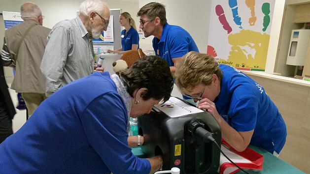 Ingeborg Essel (links) und Hygienefachkraft Doris Steffl sehen inder Schwarzlichtbox das Ergebnis einer H&auml;ndedesinfektion.Marion Kr&uuml;ger-Hundrup