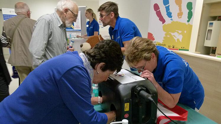 Ingeborg Essel (links) und Hygienefachkraft Doris Steffl sehen inder Schwarzlichtbox das Ergebnis einer Händedesinfektion.Marion Krüger-Hundrup