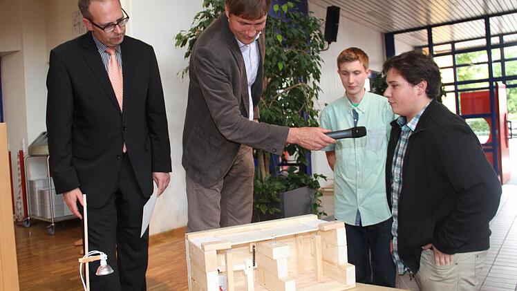 Matthias Herzog und Frank Wittmann (rechts) mit ihrem Modell einer intelligenten Straße, die auch noch Energie liefert; links im Bild Landrat Christian Meißner. Fotos: Gerda Völk