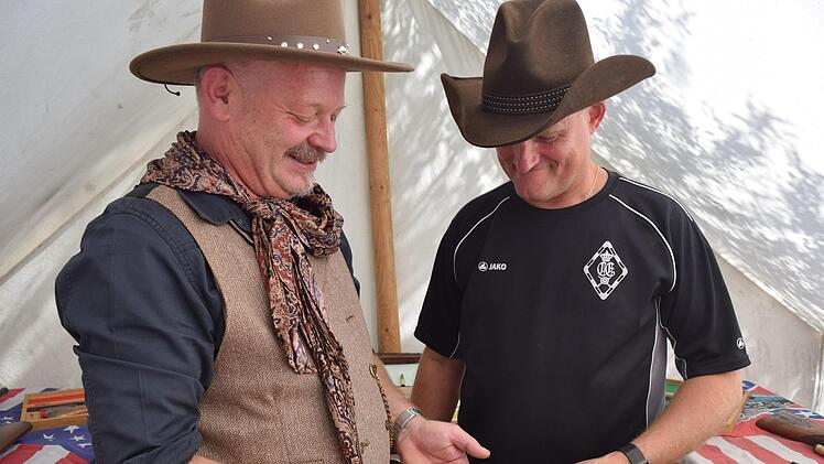 Wenn die Patrone der größten Waffe die Größe der kleinsten Waffe hat: Stephan Klose von der Privilegierten Schützengesellschaft zeigt Peter Huller auf dem Countryfestival die Vielfalt der Waffenschau. Foto: Daniela Pondelicek