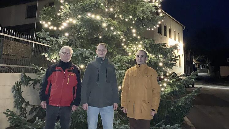 Organisator Wolfgang Bötsch  (von links) ist zufrieden. An Dominik Then ging der letzte Weihnachtsbaum,  den Kurt Back  als Bürgermeister versteigerte. Back wird nicht mehr für eine neue Amtszeit kandidieren. Foto: Hubert Ziegler