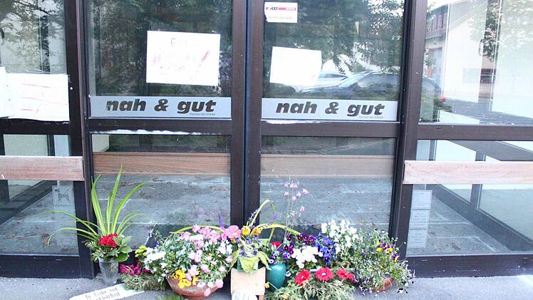 Bürger haben Blumen vor dem ehemaligen Edeka-Markt in Neudrossenfeld niedergelegt. Auf Zetteln bitten sie darum: "Macht bitte den Edeka wieder auf." Der Wunsch nach einem Vollsortimenter im Ort ist also nach wie vor groß. Foto: Jürgen Gärtner