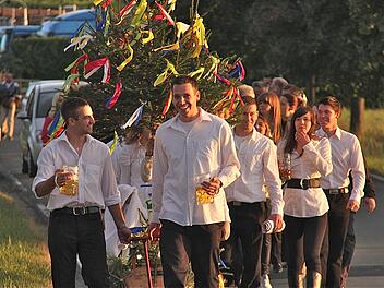 Fröhlich prostend zogen die Kirmesburschen unter Begleitung der Dorfkapelle durch Schwärzelbach zum Sportheim.  Foto: Gerd Schaar