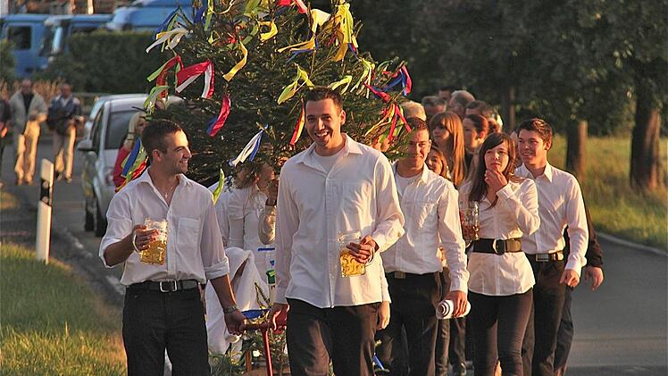 Fröhlich prostend zogen die Kirmesburschen unter Begleitung der Dorfkapelle durch Schwärzelbach zum Sportheim.  Foto: Gerd Schaar