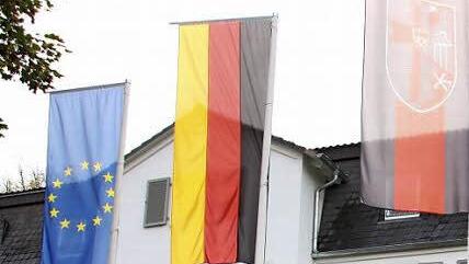 Vor dem Heiligenhof wehen die Flaggen der (von rechts) Europäischen Union, Deutschlands und der Sudetendeutschen.