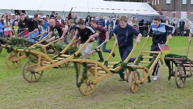 13 Teilnehmer nehmen die Schubkarren in ihre Hände und kämpfen um den Sieg beim traditionsreichen Rennen.  Fotos: Wolf