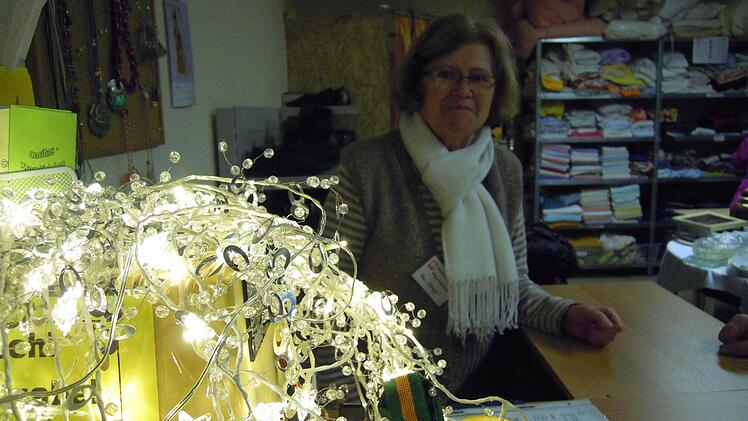 Auch hier wird ein bisschen weihnachtliche Stimmung benötigt: ehrenamtliche Helferin hinter der Kasse des Caritas-Kramlädchens. Foto: Julia Raab