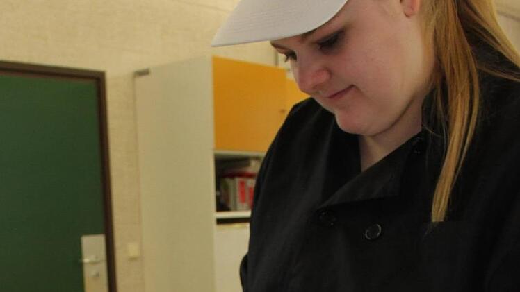 Eine Berufsfachschülerin belegt die vorgebackene Tarte mit verschiedenen bunten Rübenscheiben, bevor sie eine Mischung aus Ziegenkäse und Eiern darüber gibt und das Ganze noch einmal zum Backen in den Ofen schiebt. Fotos: Popp