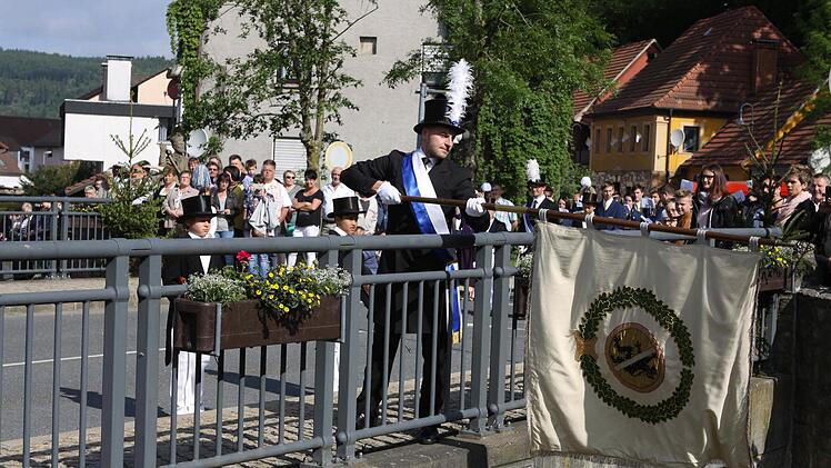 Der jüngste Stadtrat Sven Hofmann beim traditionellen Fahnenschwenken auf der Schwedenbrücke.  Foto: Michael Wunder