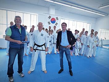 Bei der Übergabe der Geldspende des Rotary-Hilfswerkes Kulmbach (von links) Horst Hohenner, Ralph-Jörg Aman und Peter Bastobbe. Im Hintergrund die Aktiven vom Taekwon-Do Kulmbach e.V. im neuen Trainingszentrum