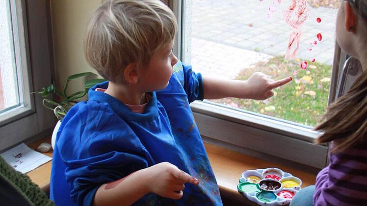 Ida malt ihre eigene Vorstellung eines Herbstbaumes an die Scheibe. Foto: Lisa Kieslinger