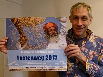 Der Bamberger Theologe Andreas Schneider hat den Ökumenischen Fastenweg organisiert. Er zeigt das Plakat zur Aktion. Foto: Marion Krüger-Hundrup
