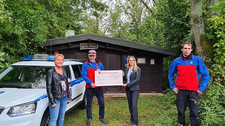 Ein Spendenscheck wird vor der Bergwacht-Hütte am Walberla überreicht (v. l.): Steffi Ribold, Thomas Vogel, Gianna Wollner  und Denis Lieb. Foto: Carmen Schwind