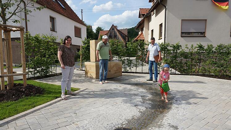 Die dreijährige Laney hat Spaß am neuen Brunnen in Schmalwasser. Mit ihr freuen sich Bürgermeisterin Sonja Reubelt, ihr Opa Hermann Endres und Michael Manger vom Amt für ländliche Entwicklung.