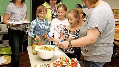 Unter den Augen von Ernährungsfachfrau Cäcilie Werner und Lehrerin Gabriele Schöttner (von links) schmeckten die Kinder einen Nudelsalat ab. Das gehörte zum Ernährungsführerschein.  Foto: Günther Geiling