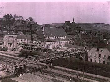 Der Bahnhof in Kronach mit der Baustelle für das (neue) Postgebäude im Jahr 1925. Vom Aufnahmestandort am Ziegelanger aus ist der frühere eiserne Fußgängersteg zwischen Bahnhofsplatz und Ziegelanger gut zu erkennen. Bei genauer Betrachtung kann man einen gerade "durchrauschenden", von einer Dampflokomotive gezogenen Personenzug erkennen. Repro: Stefan Wicklein