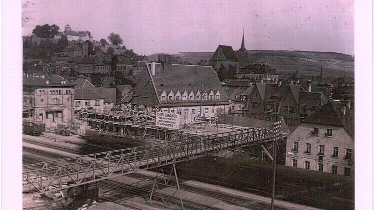 Der Bahnhof in Kronach mit der Baustelle für das (neue) Postgebäude im Jahr 1925. Vom Aufnahmestandort am Ziegelanger aus ist der frühere eiserne Fußgängersteg zwischen Bahnhofsplatz und Ziegelanger gut zu erkennen. Bei genauer Betrachtung kann man einen gerade "durchrauschenden", von einer Dampflokomotive gezogenen Personenzug erkennen. Repro: Stefan Wicklein