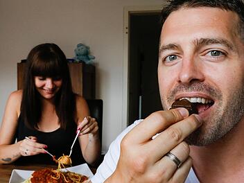 Kulinarischer Kontrast: Redakteur Christian Pack beißt in einen Vegisan-Riegel, Ehefrau Sarah lässt sich die Pasta schmecken.  Fotos: Matthias Hoch