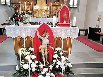 Die festlich geschmückte Statue des hl. Sebastian mit der Reliquienmonstranz (rechts) auf dem Volksaltar in der Pfarrkirche St. Thomas in Wallenfels