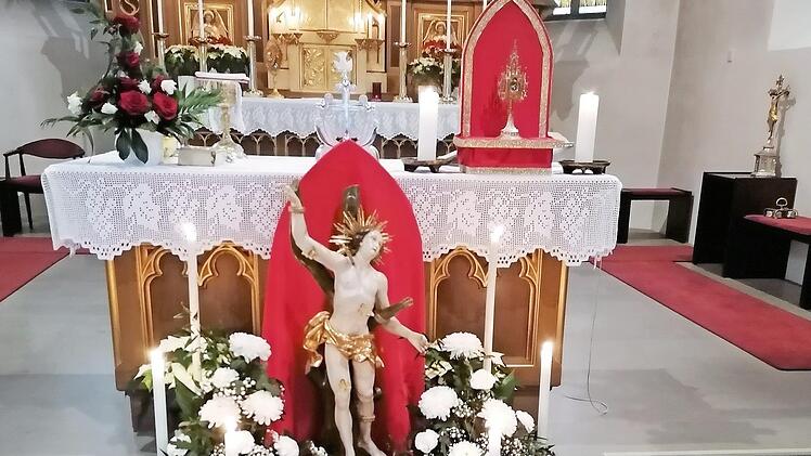 Die festlich geschmückte Statue des hl. Sebastian mit der Reliquienmonstranz (rechts) auf dem Volksaltar in der Pfarrkirche St. Thomas in Wallenfels