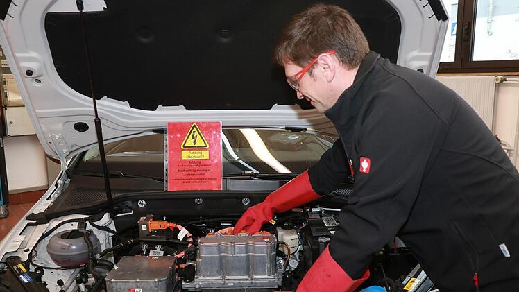 Kfz-Ausbildungsmeister Gerhard Schmökel zeigt im Ausbildungszentrum der Handwerkskammer für Oberfranken in Bayreuth, worauf man beim E-Auto achten muss. HWK