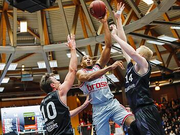 Augustine Rubit setzt sich unter dem Korb gegen die Crailsheimer Konrad Wysocki (l.) und Philipp Neumann (r.) durch. Der Bamberger Center hat am Samstag die Marke von 2000 Punkten in der Basketball-Bundesliga geknackt. Fotos: Daniel Löb