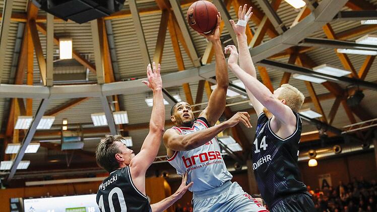 Augustine Rubit setzt sich unter dem Korb gegen die Crailsheimer Konrad Wysocki (l.) und Philipp Neumann (r.) durch. Der Bamberger Center hat am Samstag die Marke von 2000 Punkten in der Basketball-Bundesliga geknackt. Fotos: Daniel Löb