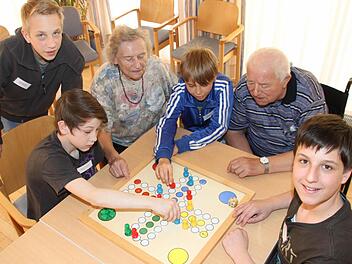 Lars Hellmuth, Marvin Walther, Nick Ehrhardt und Sandro Biener (v.l.) unterhielten die Senioren im Pflegeheim Seniore Residenz Wirsberg. Hier spielen sie "Mensch ärgere dich nicht" mit den Senioren Anneliese Türk und Andreas König. Foto: Sebastian Martin