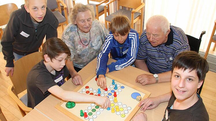 Lars Hellmuth, Marvin Walther, Nick Ehrhardt und Sandro Biener (v.l.) unterhielten die Senioren im Pflegeheim Seniore Residenz Wirsberg. Hier spielen sie "Mensch ärgere dich nicht" mit den Senioren Anneliese Türk und Andreas König. Foto: Sebastian Martin