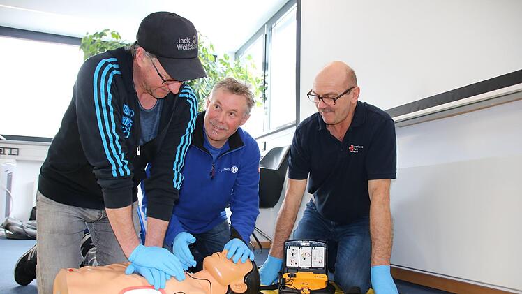 Unter Anleitung von Rettungsassistent Uve Bartz (rechts) üben Frank Keidel und Ulf Wagner an einer Puppe die Herz-Lungen-Wiederbelebung: 30 Mal drücken, dann zwei Atemstöße. Foto: Ralf Ruppert