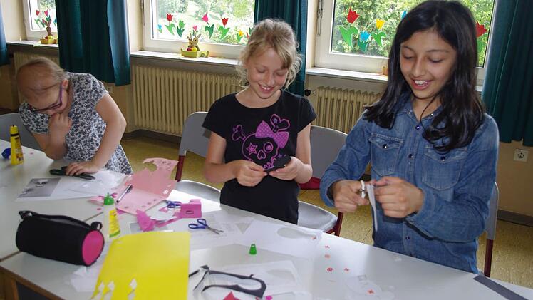 Anna-Maria, Laura und Latife basteln Pinguine.