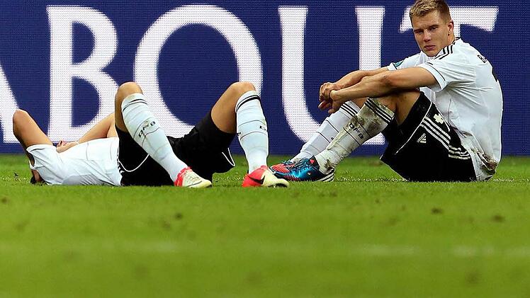 Am Boden, und der Blick  geht ins Leere:  Holger Badstuber (rechts) und Mesut Özil  nach der Halbfinal-Niederlage in Warschau  am Donnerstagabend.