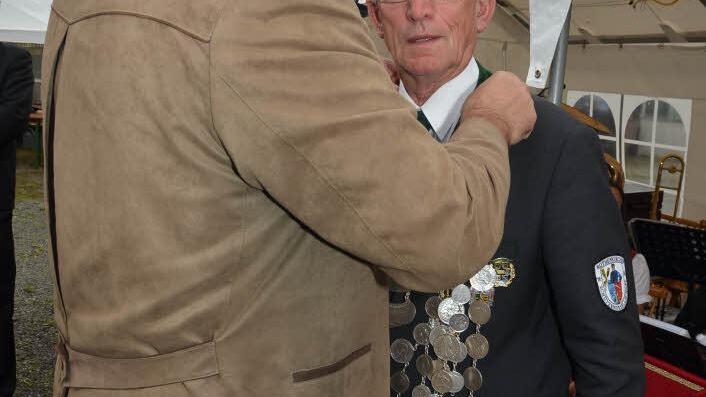 Zweiter Schützenmeister Wolfgang Bergmann hat die Ehre, den Ehrenschützenmeister und Schützenmeister und neuen Schützenkaiser, Reinhold Wolf, die Königskette umzuhängen.Fotos: K.- H. Hofmann