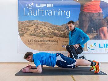 Coach Wolfgang Müller zeigt Sportredakteur Jürgen Schmitt eine Übung zur Kräftigung der Rumpfmuskulatur.Anand Anders