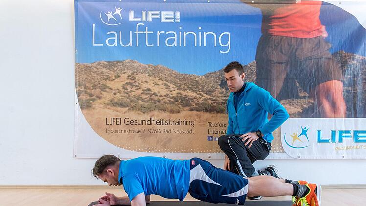 Coach Wolfgang Müller zeigt Sportredakteur Jürgen Schmitt eine Übung zur Kräftigung der Rumpfmuskulatur.Anand Anders