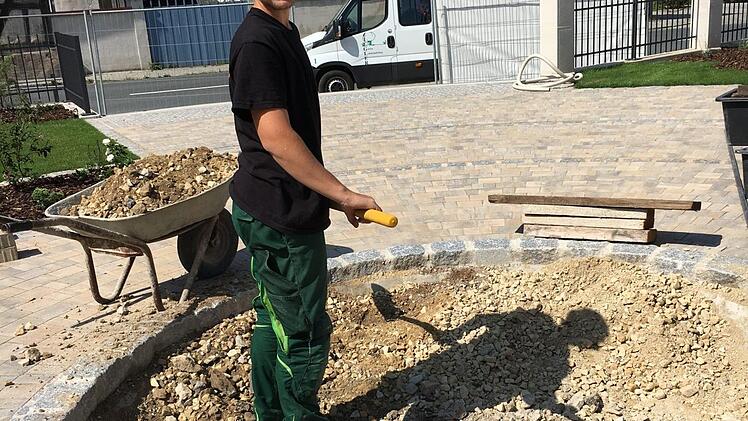 Azubi Max Hartmann arbeitet am Brunnen Anette Schreiber