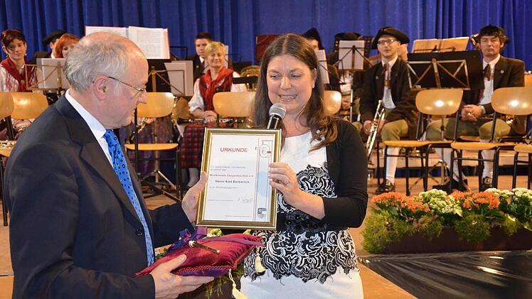 Anke Wagner, die Vorsitzende des Musikvereins, überreicht Karl Berberich beim großen Abschiedsabend die Ehrenurkunde. Fotos: Andrea Spörlein