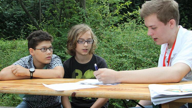 Der Unileiter Florian (rechts) gibt Daniele und Nick (von links) gerade ein Seminar zur Weiterbildung.