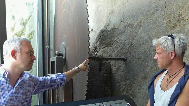 Natursteinwerk-Geschäftsführer Martin Graser (links) erläutert die Arbeitsweise einer Blockkreissäge. Rechts im Bild der Bildhauer Sören Ernst aus Schweinfurt. Foto: Sabine Meißner