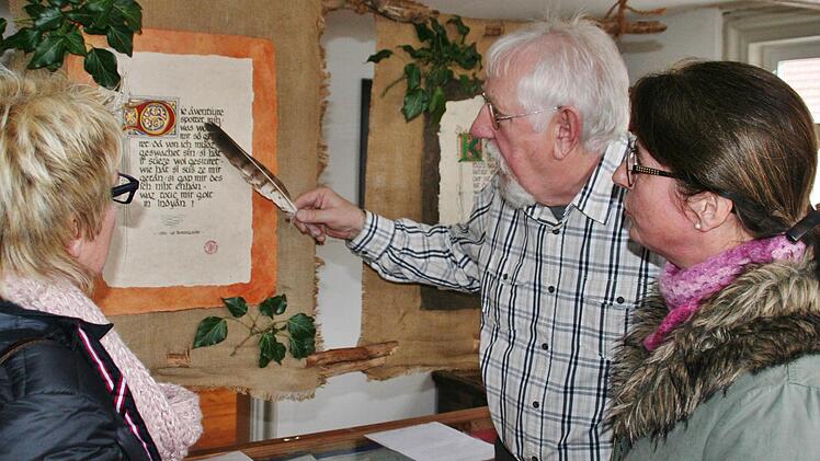 Reinhold Schädlich zeigt den Besuchern die kunstvoll verzierten Initialen der Minnelieder. Foto: Werner Vogel