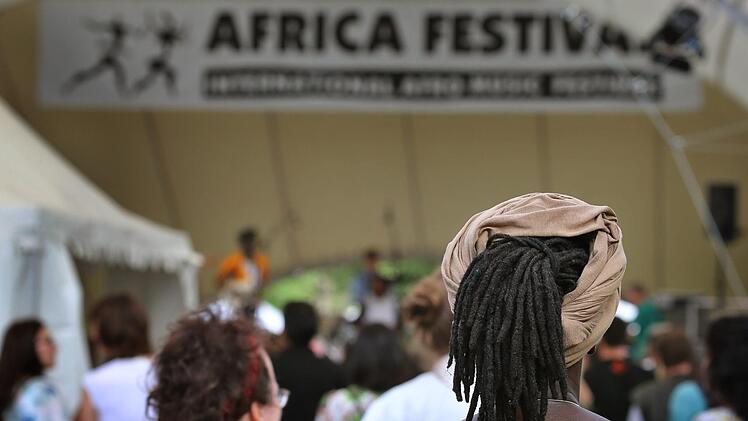 Würzburg: Besucher des Africa-Festivals stehen vor der offenen Bühne. Das Africa Festival in Würzburg lenkt jährlich nicht nur den Blick auf die vielfältige Musik des Kontinents, sondern auch auf Probleme wie Rassismus und Klimawandel. Am Pfingstwochenende 2020 wollen die Veranstalter etwa auf die Dürre in der Sahelzone aufmerksam machen. Foto: Karl-Josef Hildenbrand/dpa