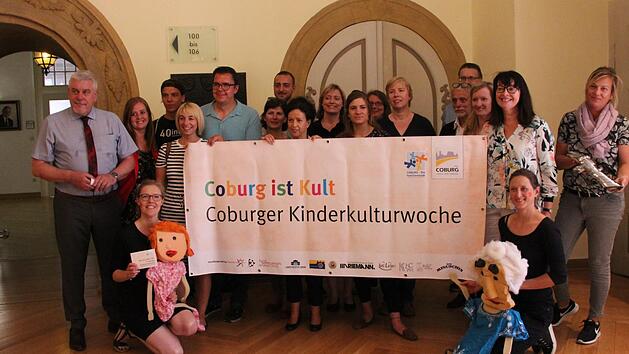 Die Organisatoren und Unterst&uuml;tzer der Kinderkulturwoche zeigen das Banner des Events vor.Saskia Nauer