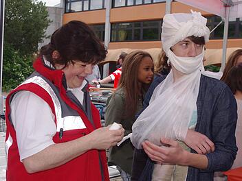 Erste Hilfe-Ausbilderin Kerstin Köhlerschmidt verwandelt Cristian in eine Mumie.  Foto: Heike Schülein